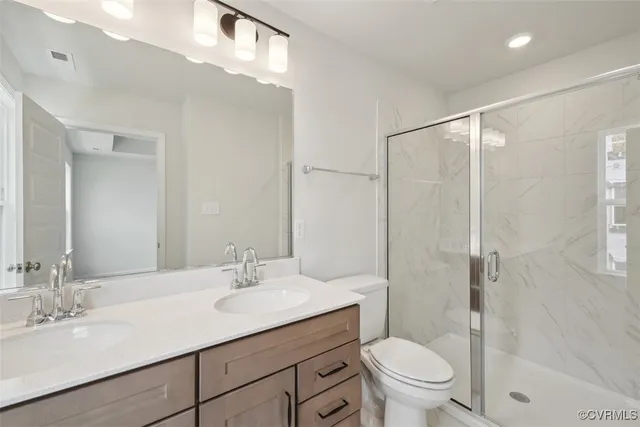 a bathroom with a sink toilet vanity and shower