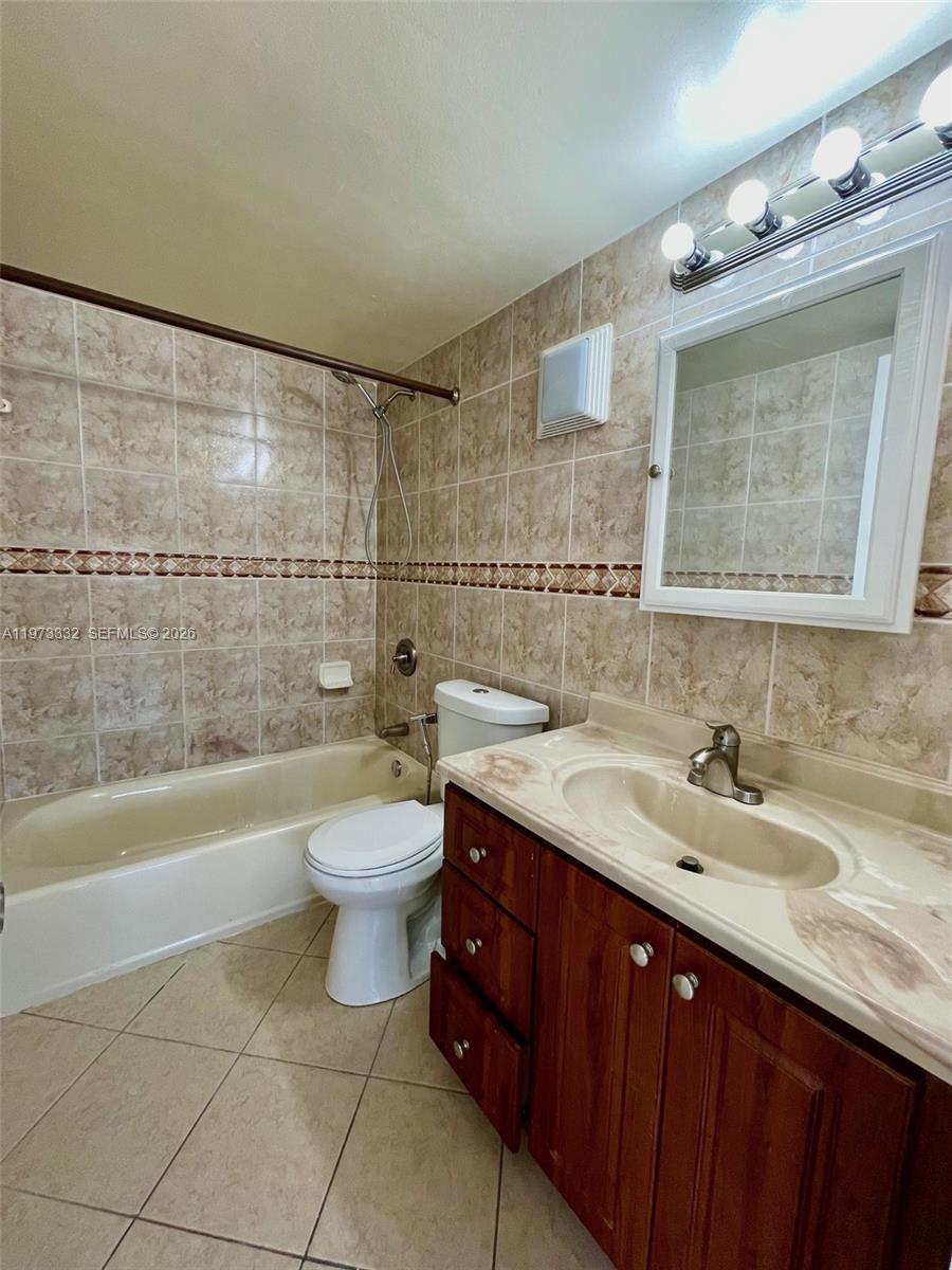1035 West 77th Street, Unit 412 Hialeah, FL 33014 - Photo 12 of 20 a bathroom with a double vanity sink toilet mirror and bathtub