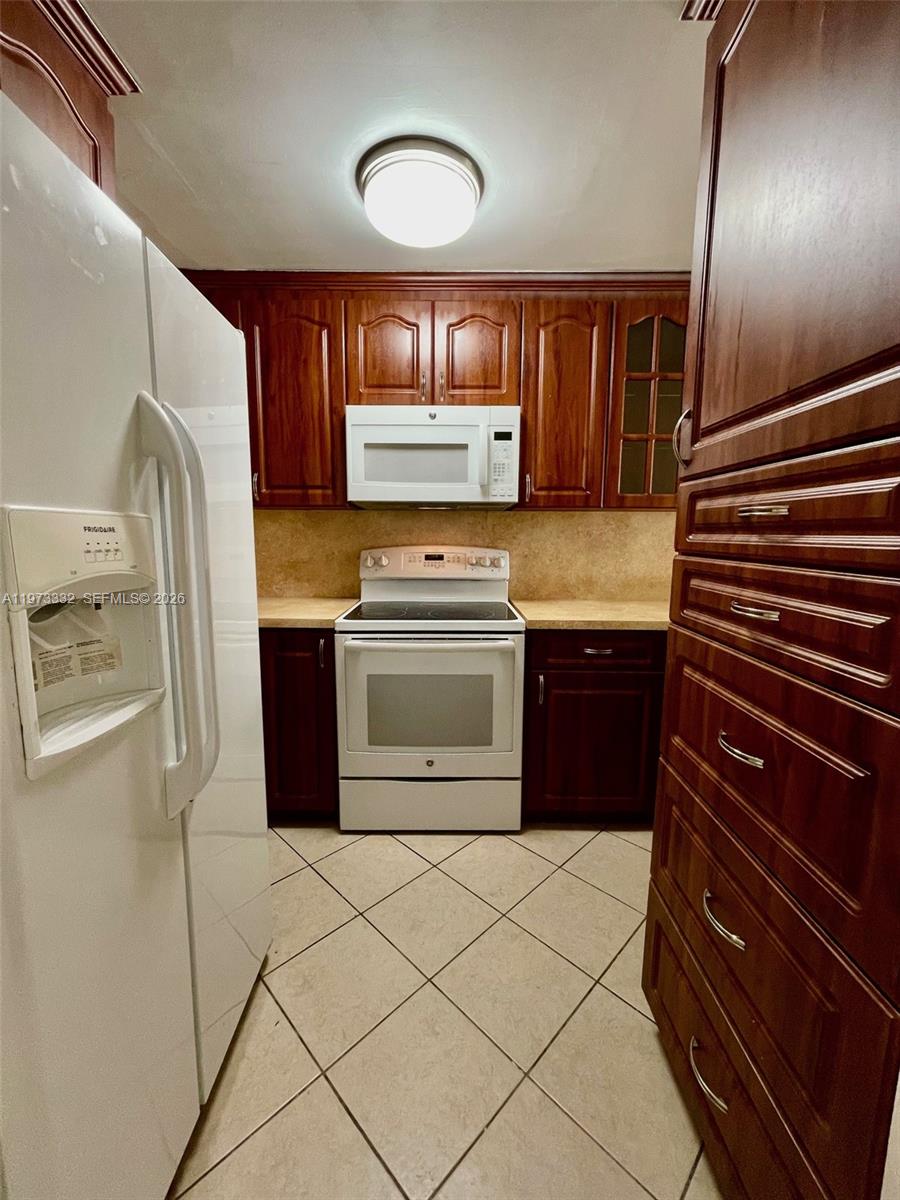 1035 West 77th Street, Unit 412 Hialeah, FL 33014 - Photo 7 of 20 a kitchen with stainless steel appliances granite countertop a stove and a refrigerator