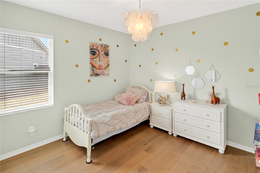 3363 Southwest 115th Terrace Gainesville, FL 32608 - Photo 25 of 43 a bedroom with a bed and a chandelier