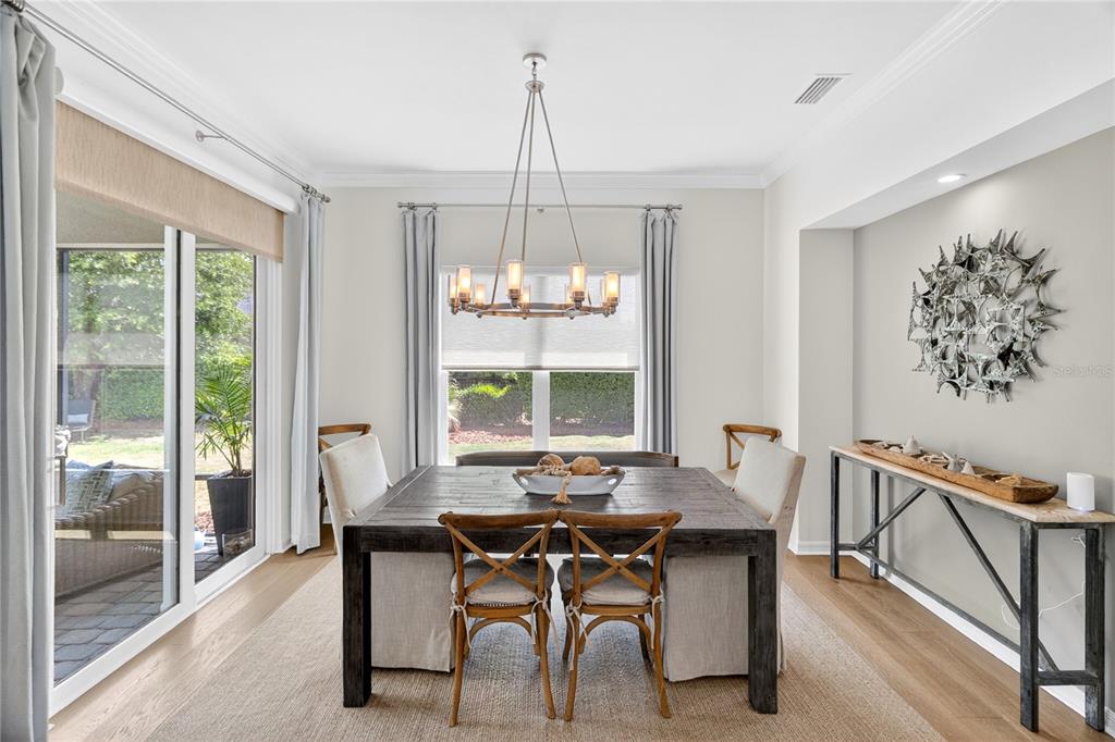 3363 Southwest 115th Terrace Gainesville, FL 32608 - Photo 4 of 43 a dining room with furniture a chandelier and wooden floor