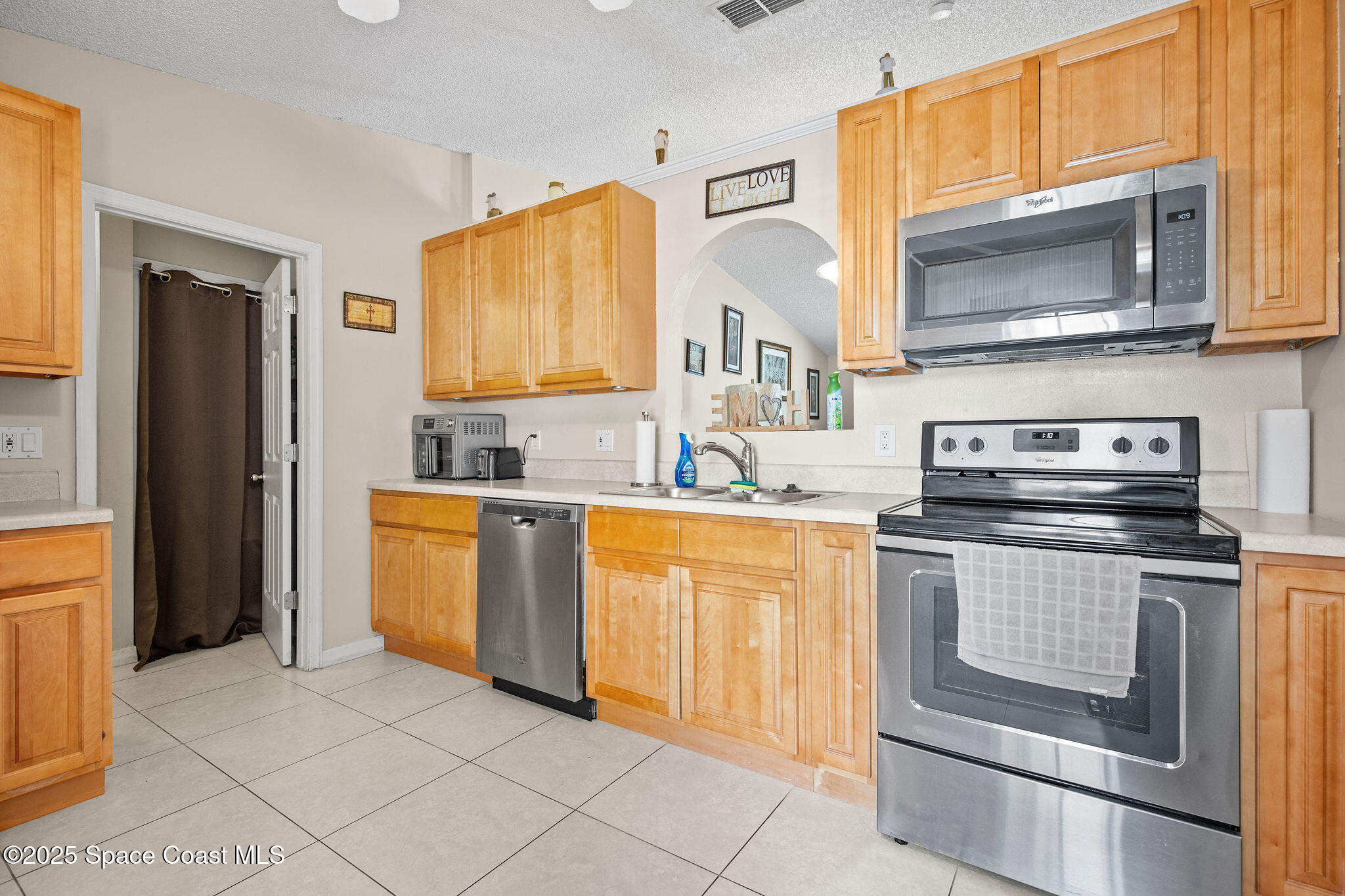 2977 Sebastian Lane Melbourne, FL 32935 - Photo 6 of 26 a kitchen with stainless steel appliances granite countertop a stove microwave and refrigerator