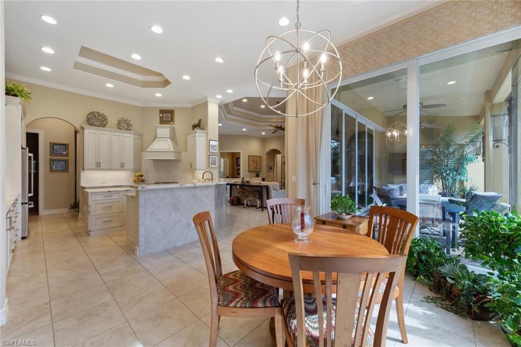 20008 Oak Fairways Court Estero, FL 33928 - Photo 19 of 49 a kitchen with stainless steel appliances kitchen island granite countertop a dining table chairs and a refrigerator