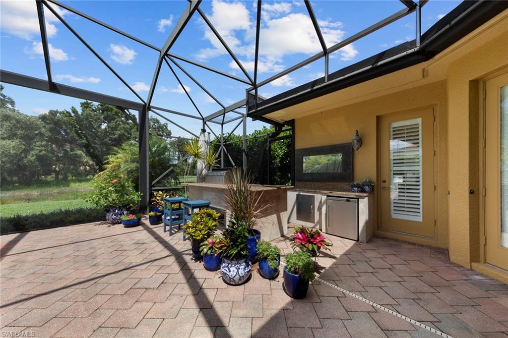 20008 Oak Fairways Court Estero, FL 33928 - Photo 41 of 49 a view of a patio with a table and chairs under an umbrella