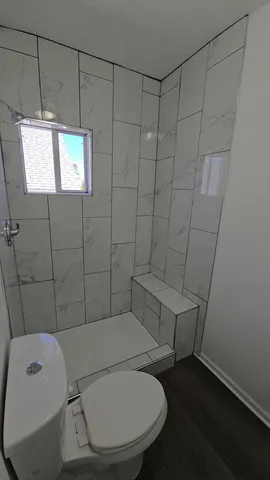 a bathroom with a toilet and a shower