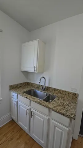 a kitchen with granite countertop a sink and cabinets