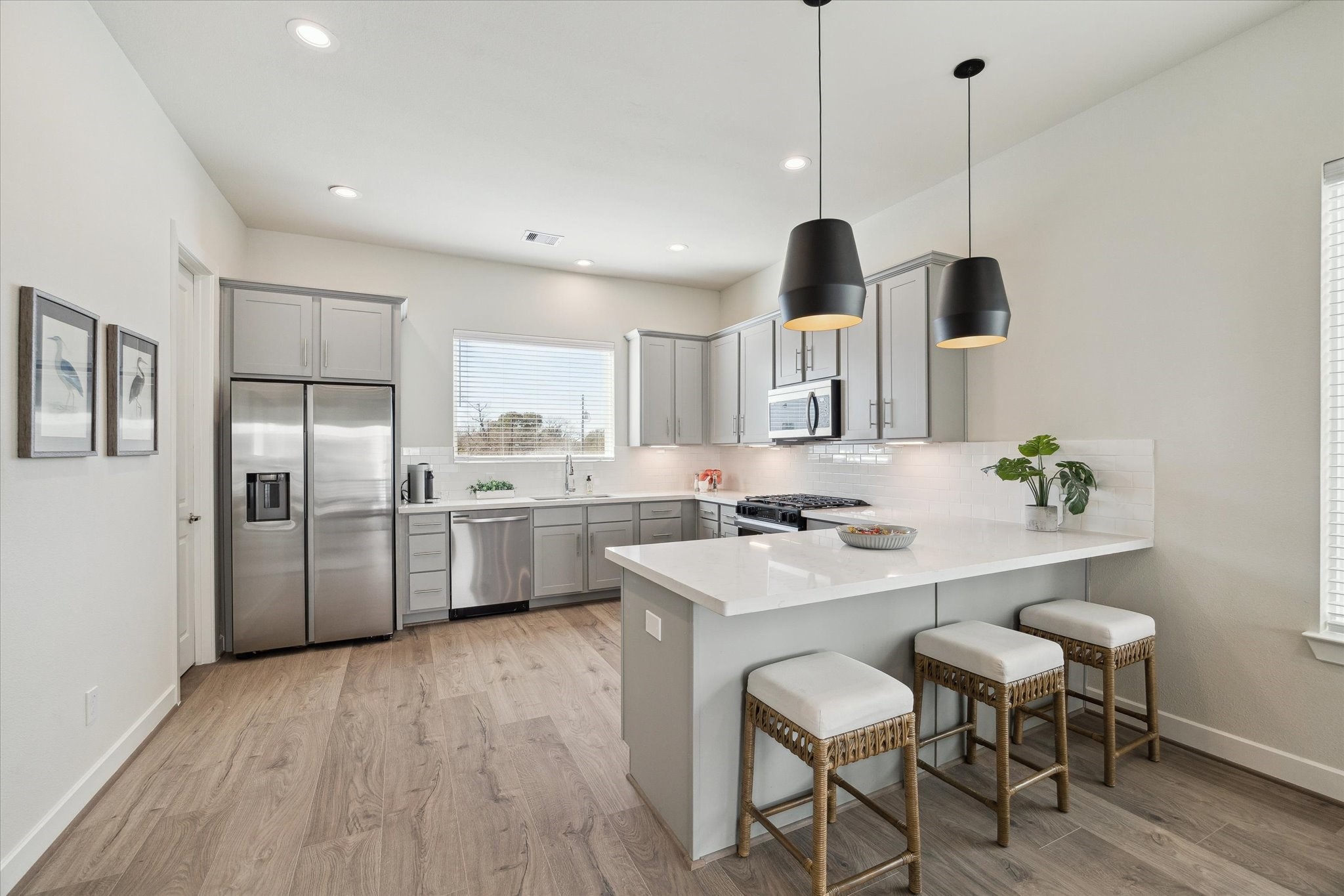 10616 Cascade Ledge Lane Houston, TX 77025 - Photo 9 of 20 A modern kitchen features quartz countertops, stainless steel appliances, and abundant cabinetry for storage.