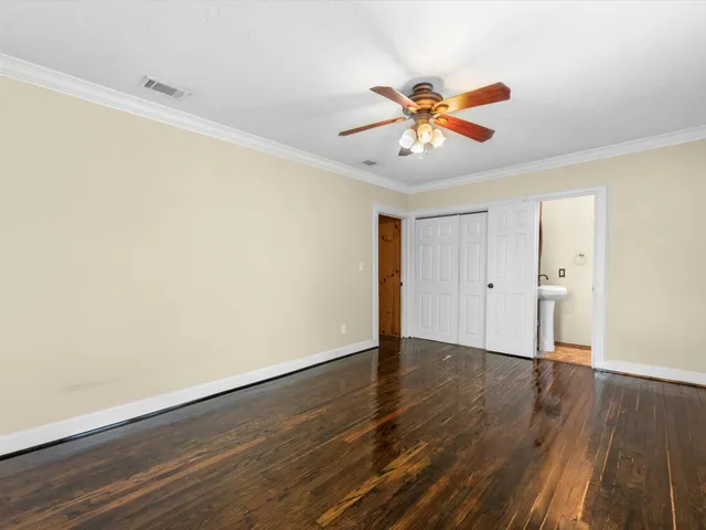 a view of a room with wooden floor and a ceiling fan