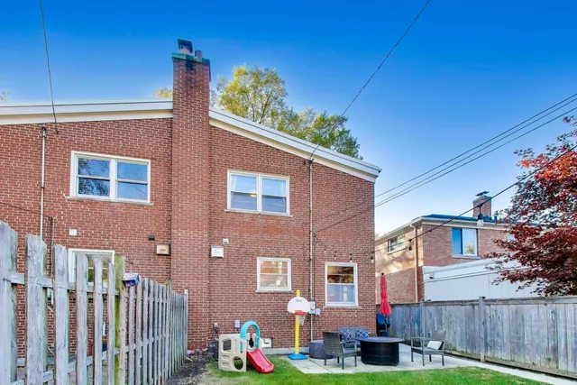 a backyard of a house with barbeque oven table and chairs