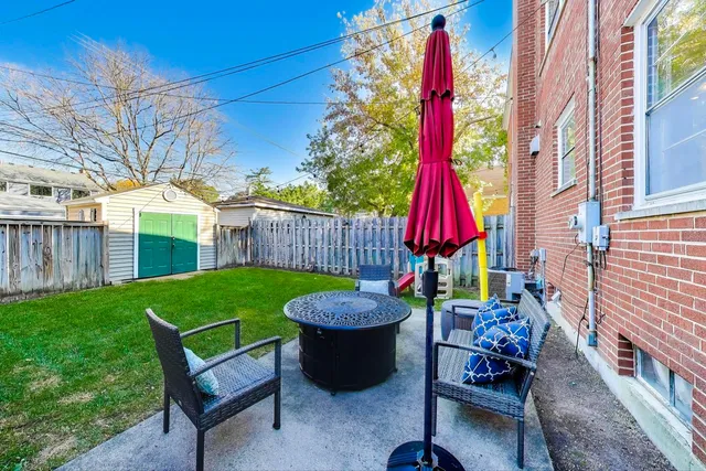 a view of a backyard with a swing and wooden fence