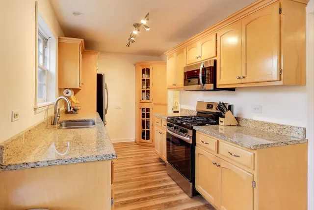a kitchen with stainless steel appliances granite countertop a sink stove and refrigerator
