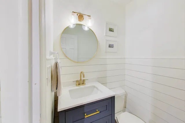 a bathroom with a toilet a sink and mirror