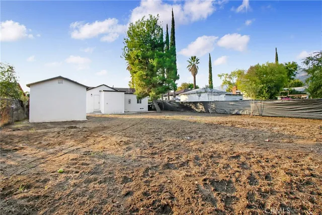 a view of a house with a yard and sitting area