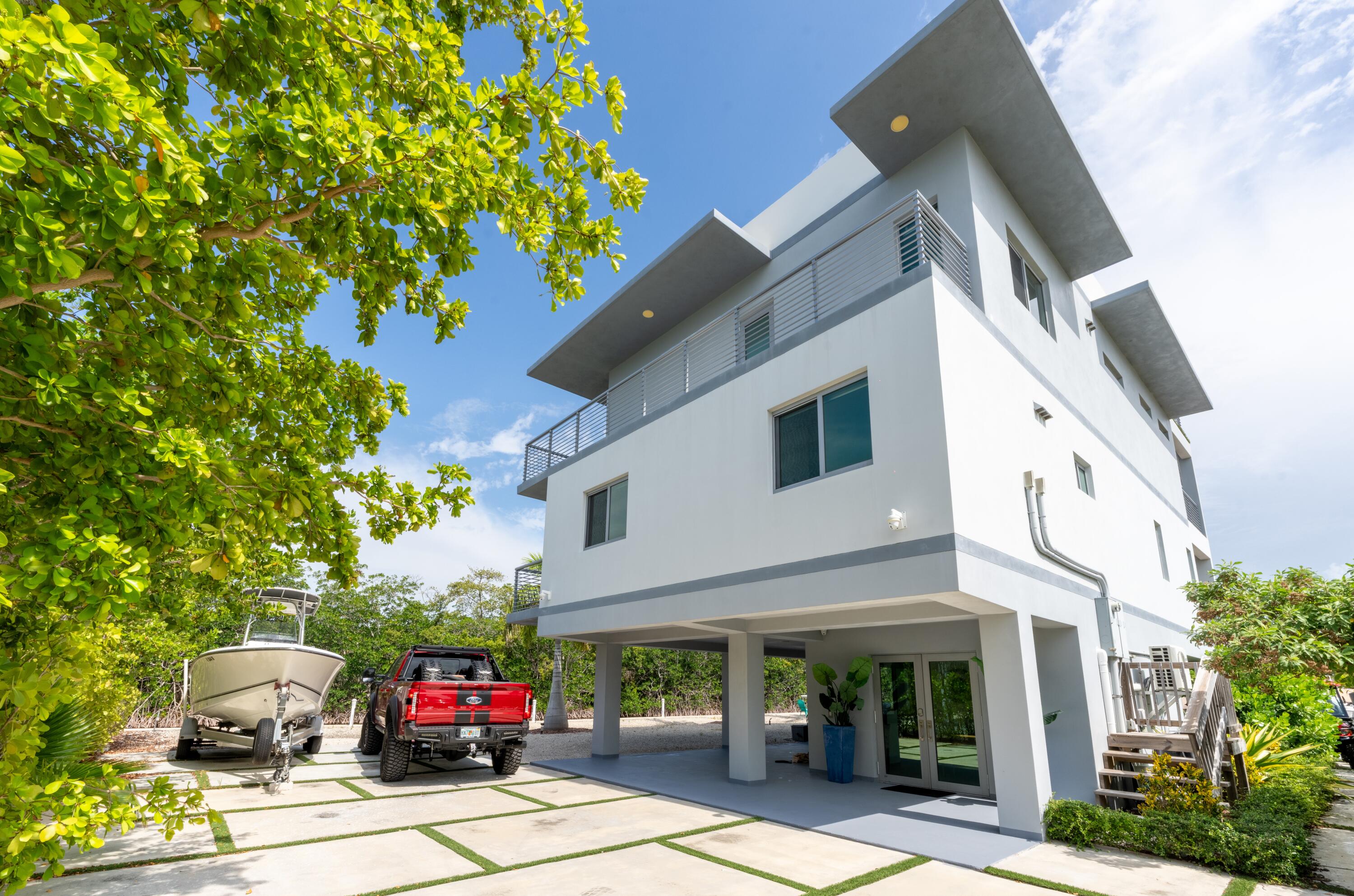 a front view of a building with lots of trees and plants
