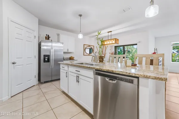 a kitchen with granite countertop stainless steel appliances a sink stove and cabinets