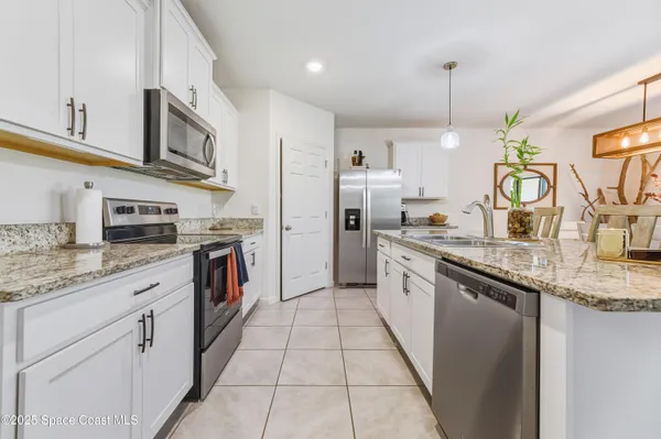 a kitchen with stainless steel appliances granite countertop a refrigerator and a stove top oven