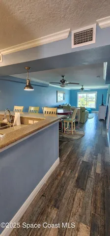 a kitchen with stainless steel appliances granite countertop a sink dishwasher a stove a dining table and chairs with wooden floor