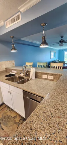 a kitchen with kitchen island granite countertop a sink cabinets and stainless steel appliances