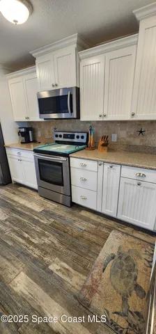 a kitchen with stainless steel appliances granite countertop a stove a sink and a white cabinets