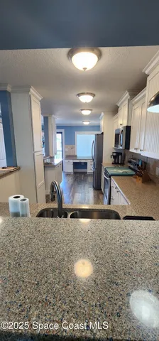 a kitchen with a sink a stove and cabinets