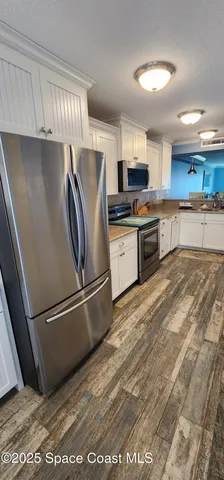 a kitchen with stainless steel appliances granite countertop a refrigerator sink and microwave