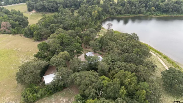 an aerial view of residential houses with outdoor space and lake view