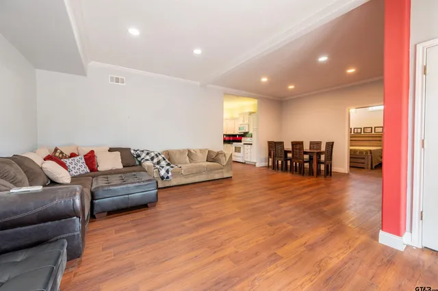 a living room with furniture and a wooden floor