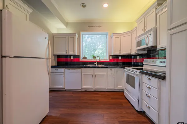 a kitchen with granite countertop a refrigerator and a sink