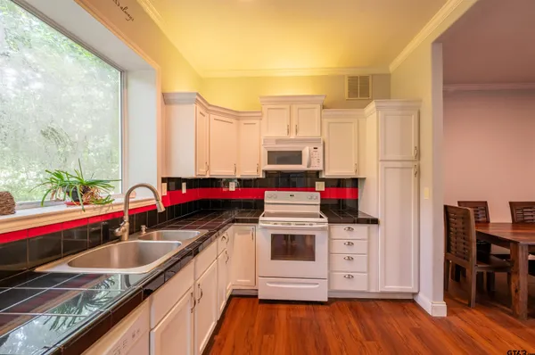 a kitchen with a sink a stove and cabinets