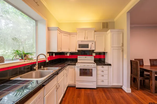 a kitchen with a sink a stove and cabinets