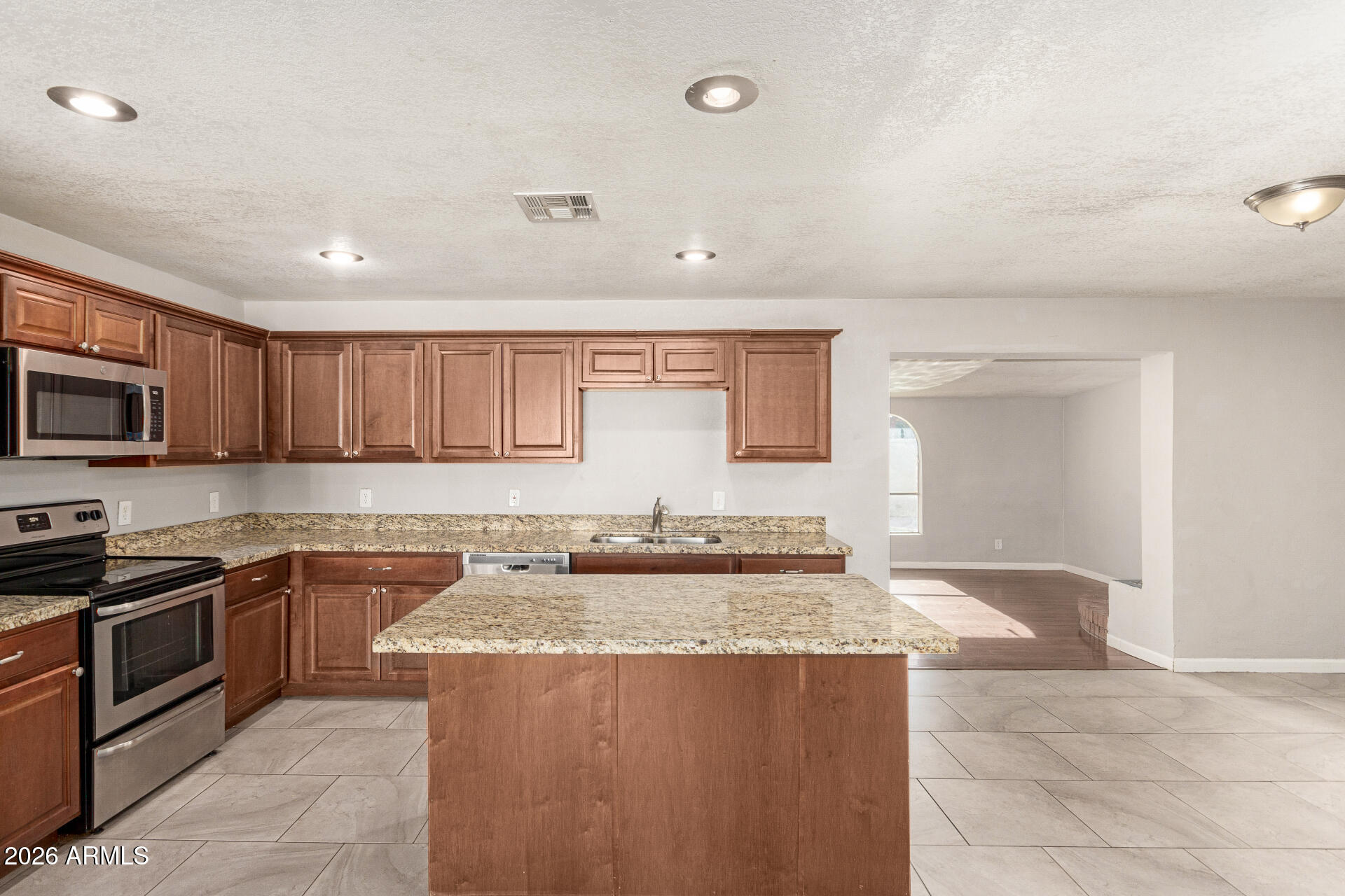 1708 North Daffodil Street Tempe, AZ 85288 - Photo 16 of 34 a kitchen with stainless steel appliances granite countertop a sink and cabinets