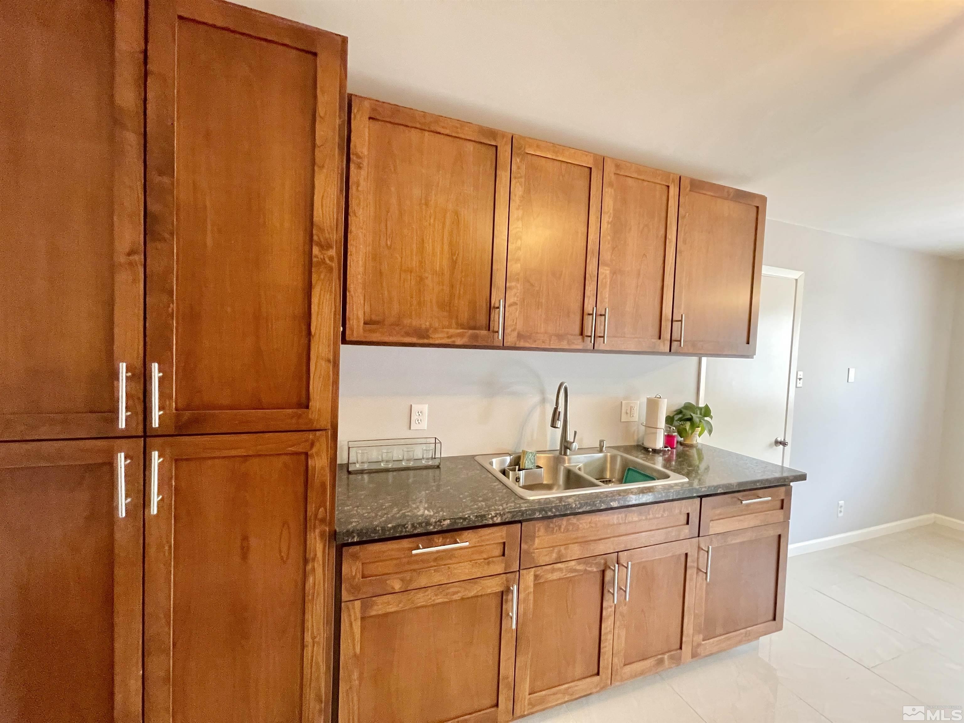 3230 Sandra Drive Reno, NV 89503 - Photo 5 of 25 a kitchen with stainless steel appliances granite countertop a sink a refrigerator and cabinets
