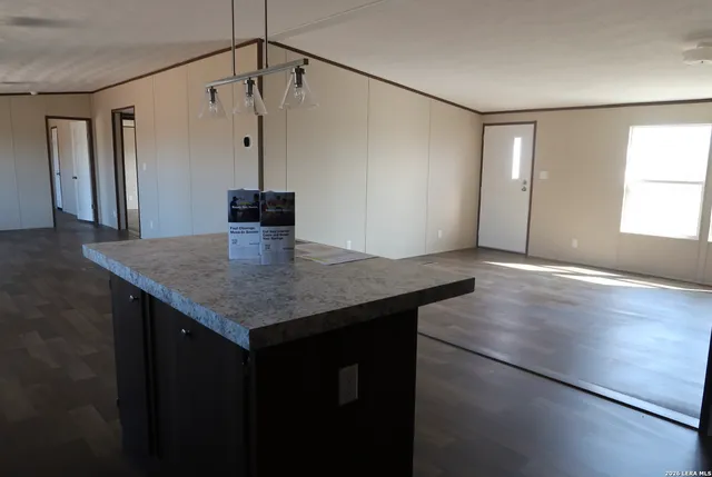 a kitchen with a sink a counter space and wooden floor