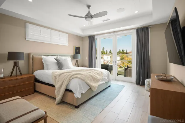 a spacious bedroom with a bed and glass walk in closet