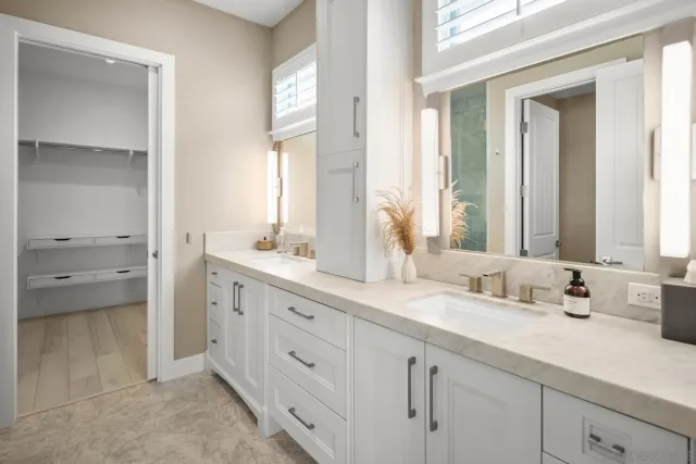 a bathroom with double sink and a mirror