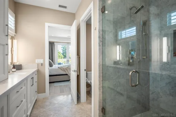 a en suite spacious bathroom with a granite countertop sink and shower