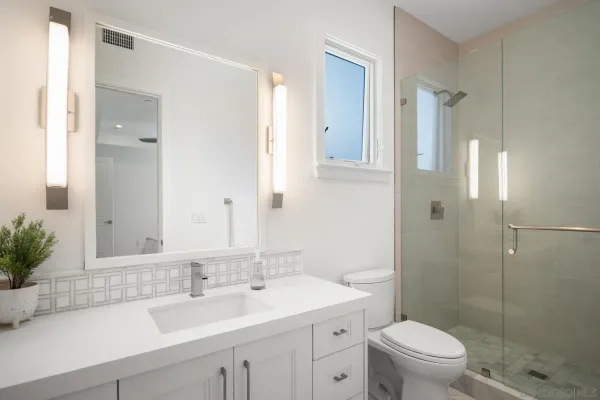 a bathroom with a sink a toilet and shower