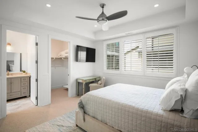 a bedroom with a large bed and a flat tv screen