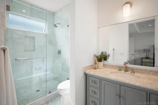 a bathroom with a granite countertop sink toilet and shower