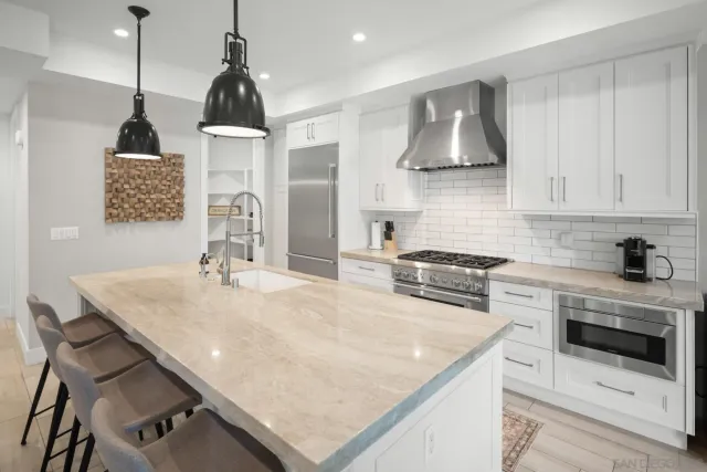 a kitchen with stainless steel appliances granite countertop a sink a stove and refrigerator