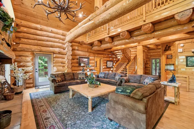 a dining room with wooden floor and large windows