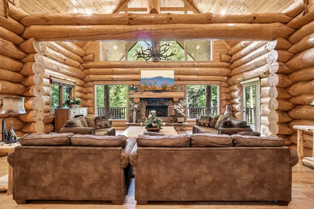 a living room with furniture a fireplace and a large window