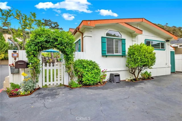 a front view of a house with a yard and potted plants