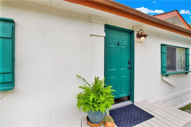 a vase with flowers sitting on a floor in front of a door