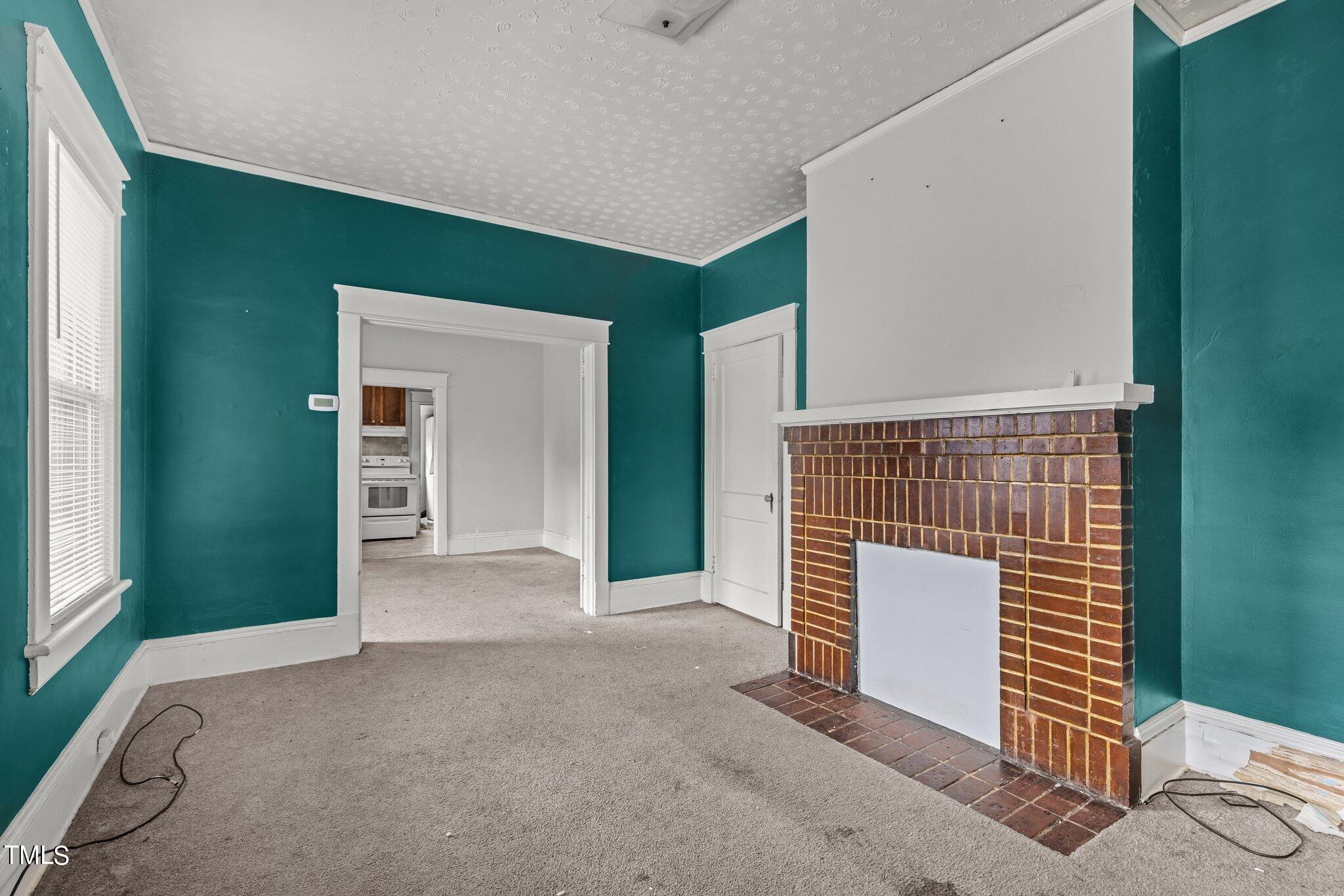 810 East Edenton Street Raleigh, NC 27601 - Photo 4 of 32 a view of empty room with windows and fireplace