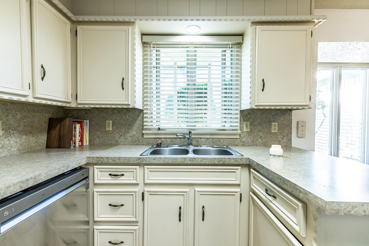 4602 63rd Street Lubbock, TX 79414 - Photo 13 of 37 a kitchen with granite countertop a sink and a window