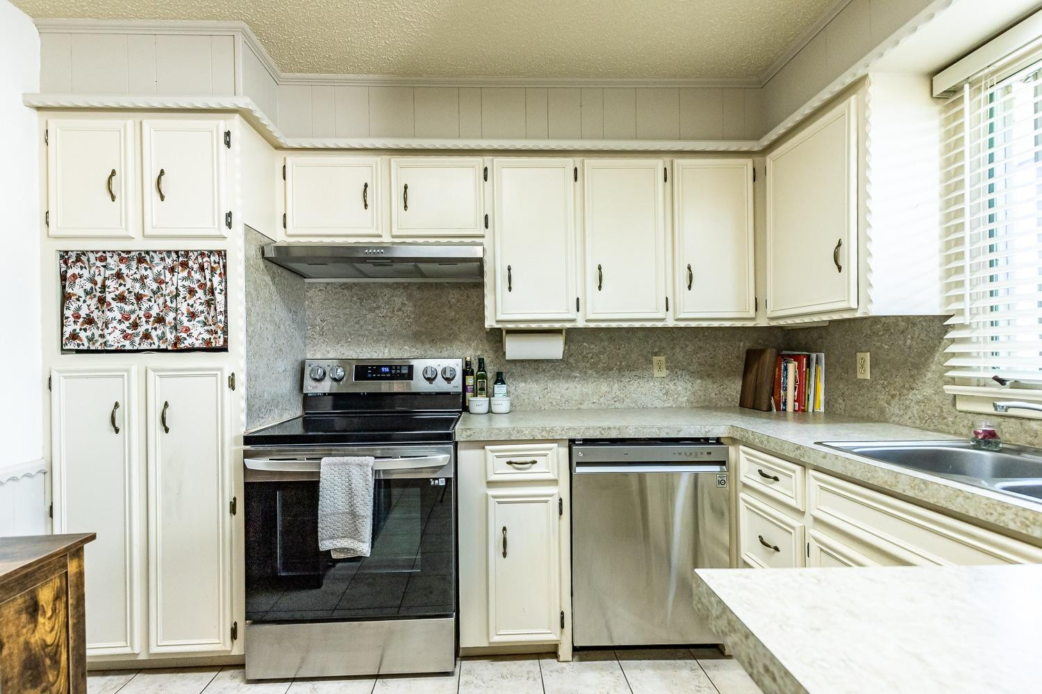 4602 63rd Street Lubbock, TX 79414 - Photo 15 of 37 a kitchen with stainless steel appliances granite countertop a stove and a refrigerator