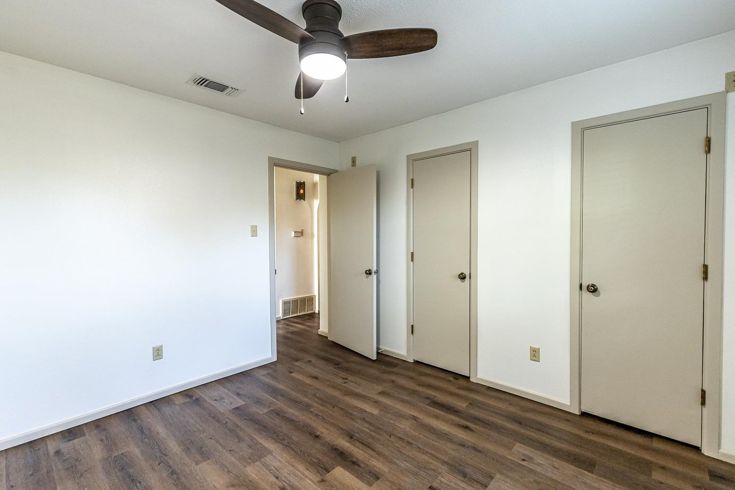 4602 63rd Street Lubbock, TX 79414 - Photo 26 of 37 an empty room with wooden floor closet and ceiling fan