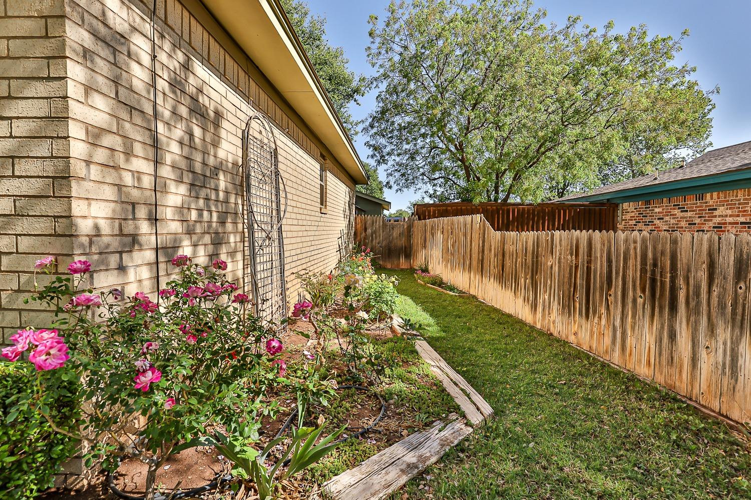 4602 63rd Street Lubbock, TX 79414 - Photo 3 of 37 a view of garden with flowers and wooden fence