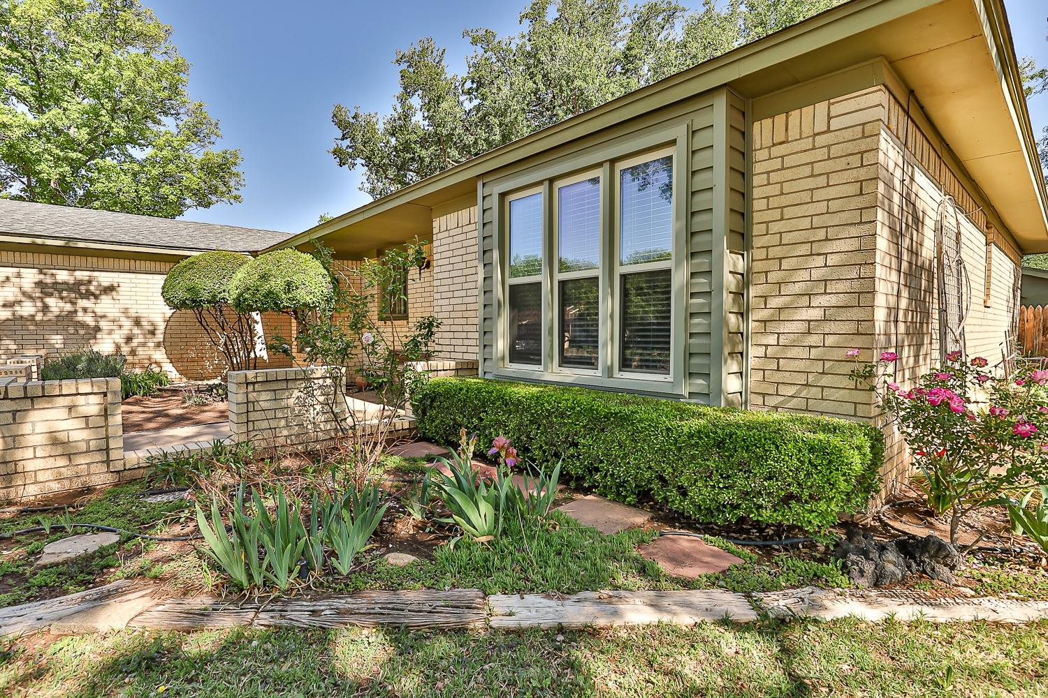 4602 63rd Street Lubbock, TX 79414 - Photo 4 of 37 a front view of a house with garden
